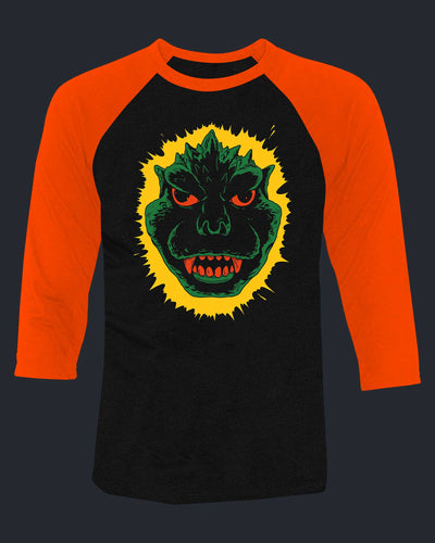 Black and orange baseball shirt with a green monster graphic on a dark background